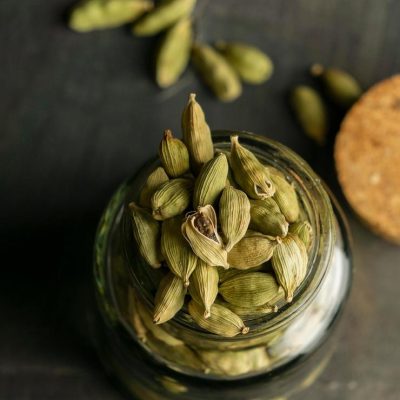 Close-up of cardamom in a small glass jar with a dark background