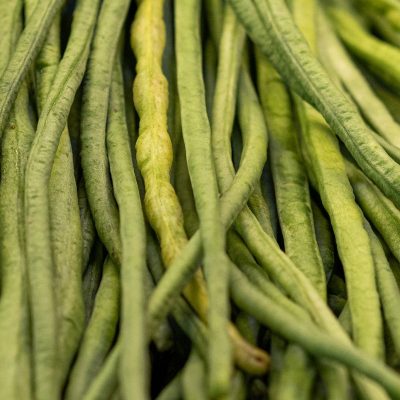 A detailed view of fresh, vibrant green yardlong beans showcasing their texture and natural color.
